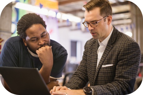 Two people looking at a laptop screen