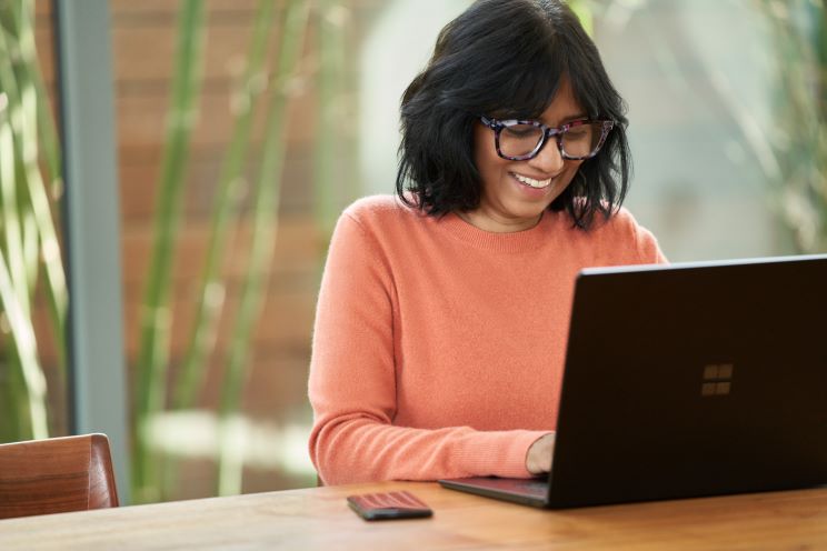 Woman happily working from laptop