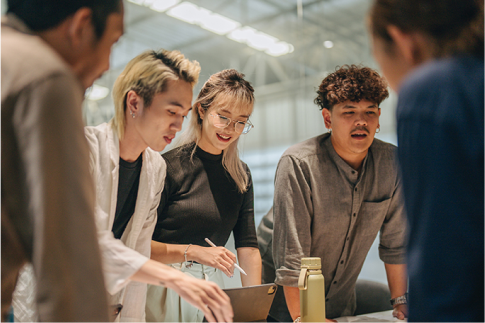 A group of people standing around a table.