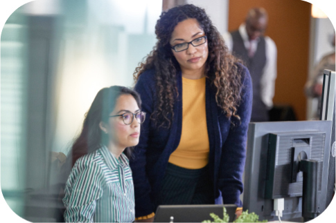 Two people reviewing information on a computer screen.