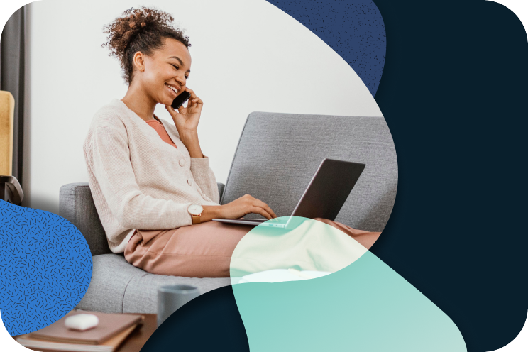 A person is sitting on a couch working on a laptop.
