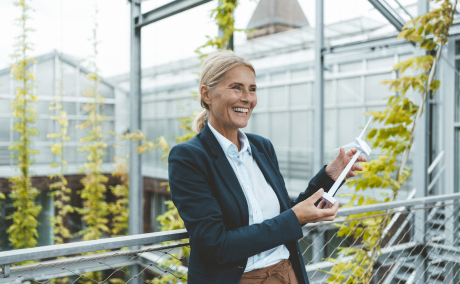 Smiling woman holding model of wind turbine