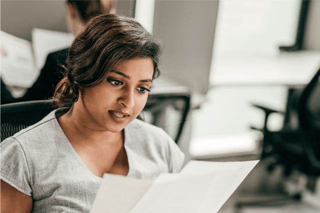 A person reviewing paperwork in an office