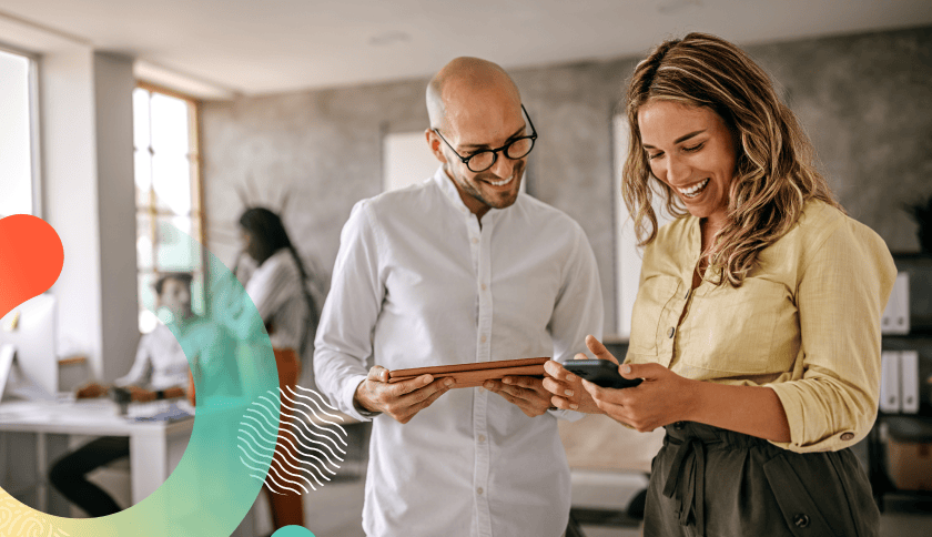 Two people looking at a tablet and cell phone