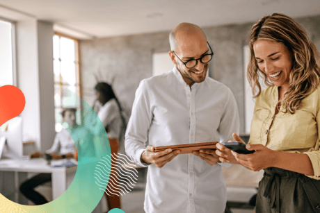 Two people looking at a tablet and cell phone