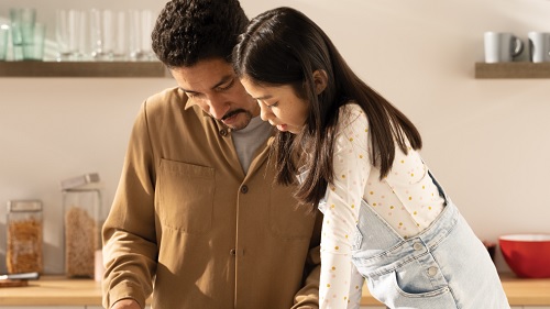 A father and a child looking at a tablet screen