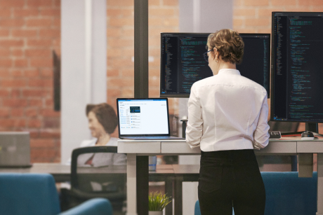 A person works at their standing desk.