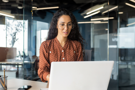 A person types on a laptop in a conference room.
