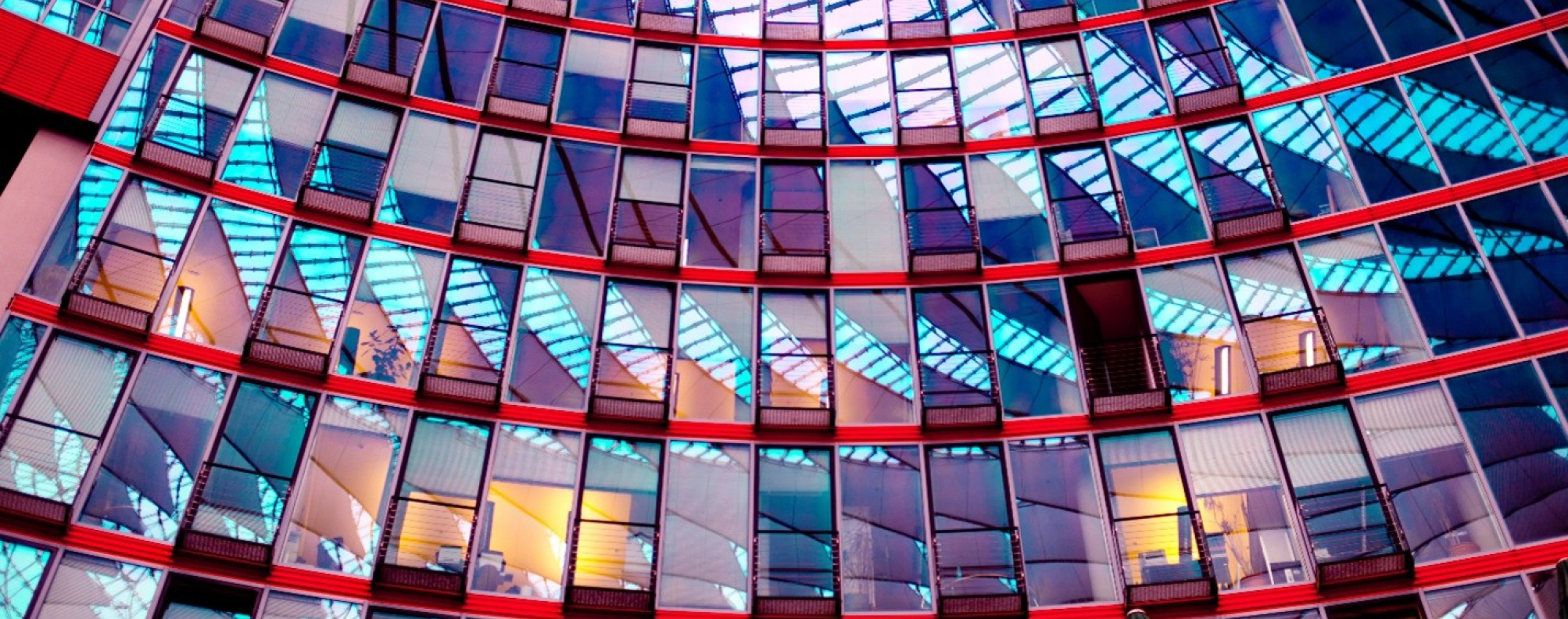 Modern glass building with reflective geometric patterns and vibrant colors.