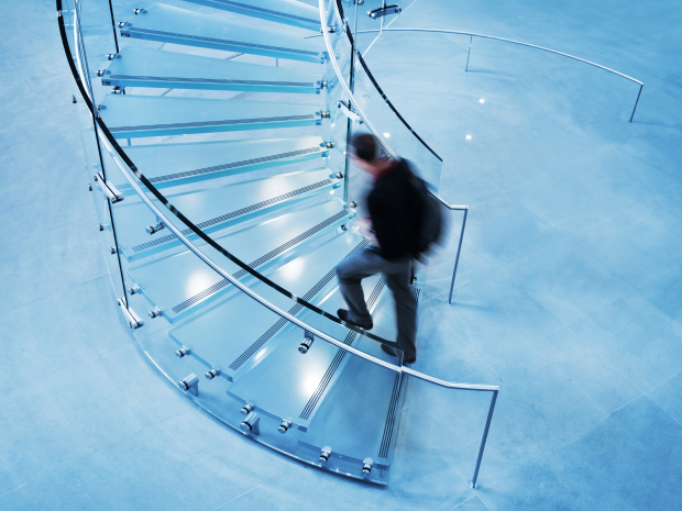 A person walking up a spiral staircase.