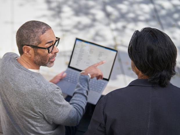 Two people discussing whats displayed on a laptop screen