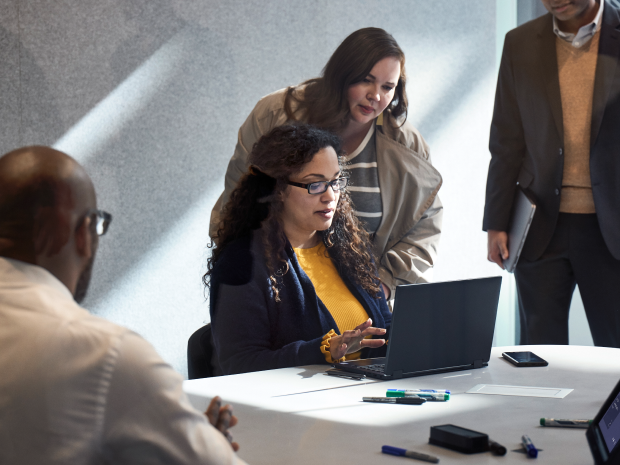 Two colleagues viewing a laptop screen in an office.