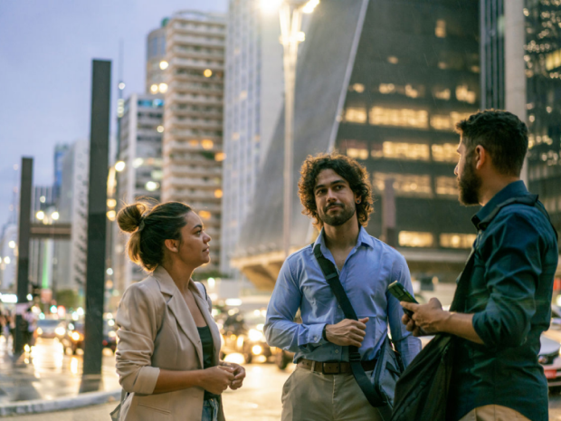 Three people having a conversation on a city street.