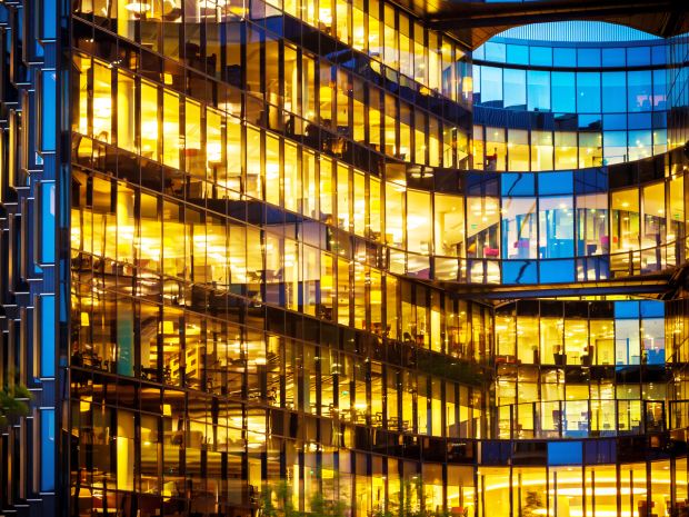 A modern business hub is brightly illuminated at night, showcasing multiple floors and interior space