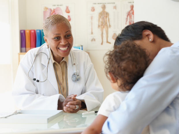 A smiling doctor seeing a young patient.