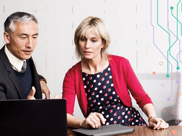 A man and woman in professional attire looking at a laptop together. Photo has a graphic overlay of circuitry design.