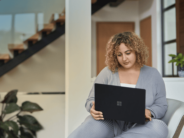 A woman looking at her laptop in an office