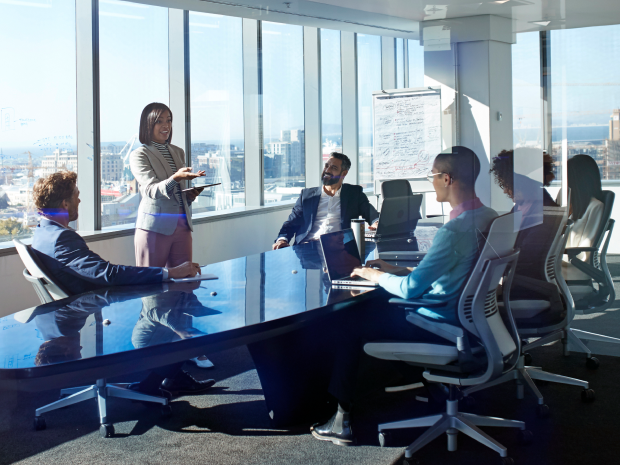 A group of professionals collaborates in a modern conference room with large windows and city views.