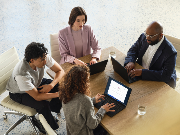 A mixed-gender team collaborates in an office space.