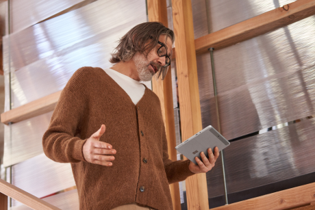 Person walking down stairs while using a tablet.