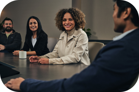 People sitting around a conference table smiling