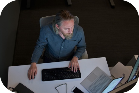 A person is viewed from above working on a laptop