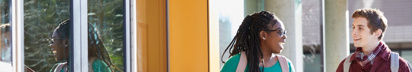 Two students arrive at a campus building