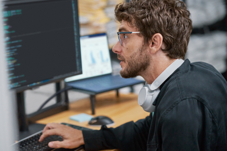 Person at a desk with a keyboard and monitor