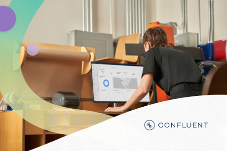 A person at a standing desk looking at charts on a computer