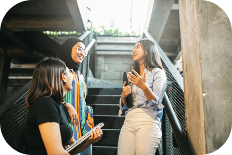 Tres personas conversan en una escalera exterior