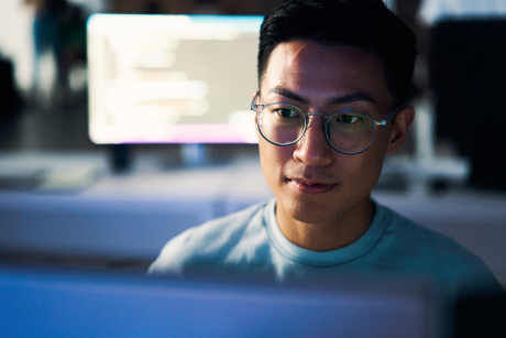 Person wearing glasses looking at a computer screen