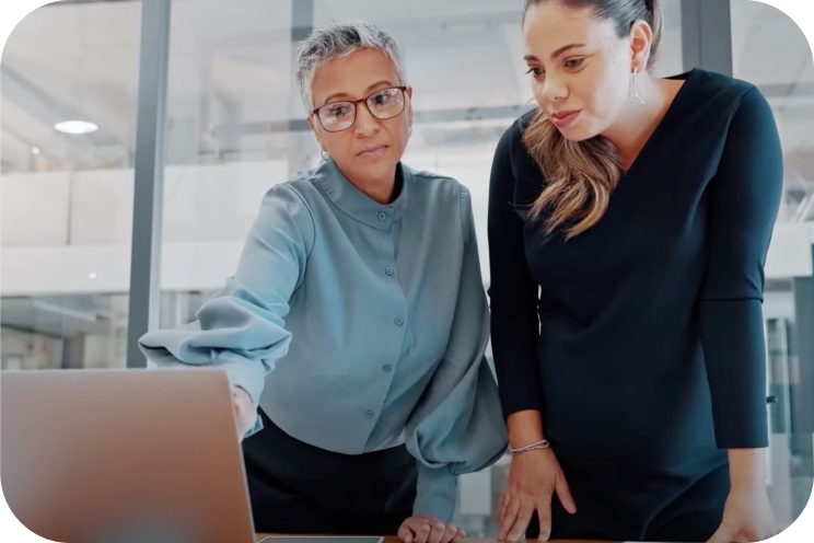 Two people hovering over a laptop