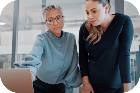 Two people hovering over a laptop