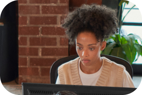 A person sits at a desk looking at a computer monitor