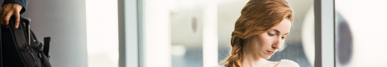 A woman works in an airport while awaiting her flight