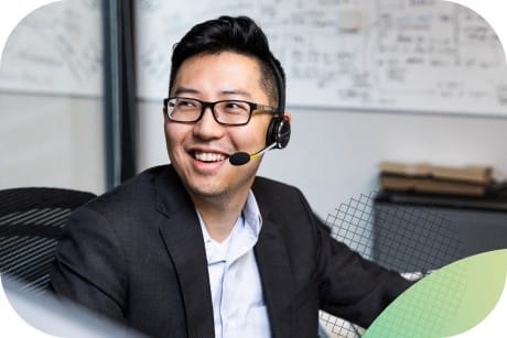 A person sitting at a desk wearing a headset