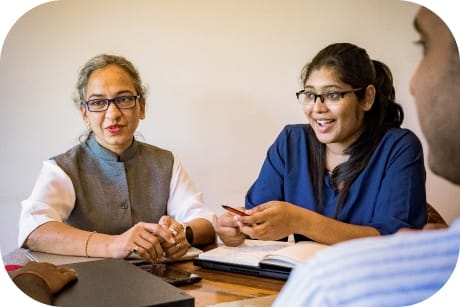 Tres personas conversan sentadas alrededor de una mesa