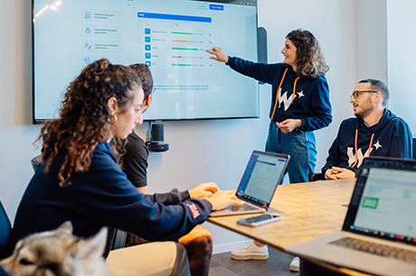 Colleagues in a conference room watching a woman presenting