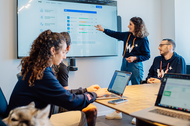 Colleagues in a conference room watching a woman presenting