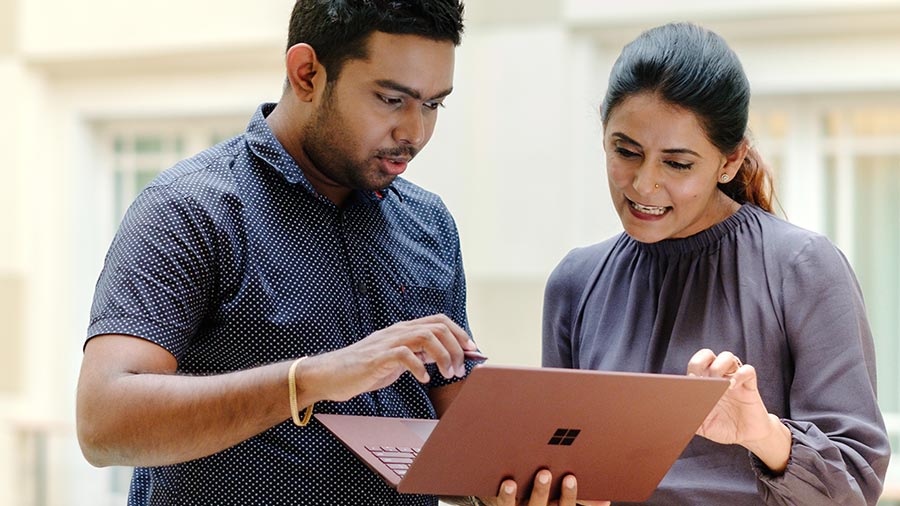 man and woman discussing on laptop