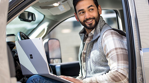 man working on laptop in a truck
