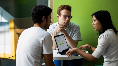 two man and woman discussing on laptop