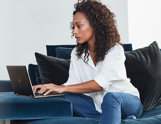 Person with serious expression working on laptop