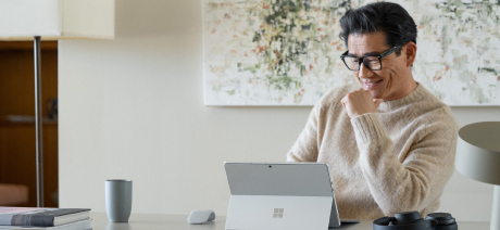 A smiling professional stares at a laptop