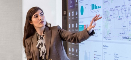 Professional woman in brown suit presenting analytics data
