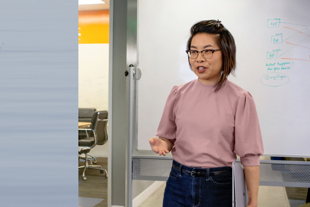 A person presenting in front of a whiteboard