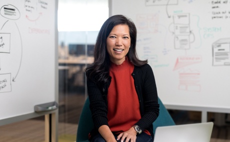 Executive businesswoman smiling at the camera and a whiteboard in the background