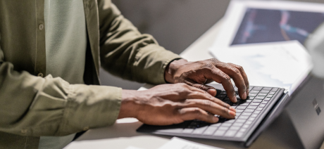 Person’s hands typing on a keyboard.