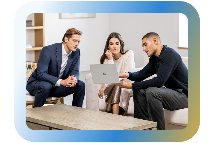 Three people looking at a laptop.