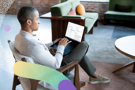 A person sitting on a chair with a laptop